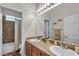 Bathroom with double sinks, neutral countertops, framed mirror, and a shower-tub combo at 7228 Fern Meadow St, Las Vegas, NV 89149