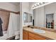 Well-lit bathroom featuring a shower-tub combo and a single-sink vanity with tile countertop at 7228 Fern Meadow St, Las Vegas, NV 89149