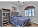Bedroom with a dark wood frame bed, shelving unit, and sunburst window shade at 7228 Fern Meadow St, Las Vegas, NV 89149