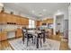 Inviting kitchen features wooden cabinetry, tile backsplash, and a central island with seating and wood dining table at 7228 Fern Meadow St, Las Vegas, NV 89149