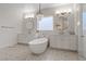 Bright bathroom features a standalone tub beneath a chandelier, along with dual sinks and a glass-enclosed shower at 7289 Sea Anchor Ct, Las Vegas, NV 89131