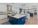 Open kitchen featuring a navy island with a marble countertop and stainless steel appliances at 7289 Sea Anchor Ct, Las Vegas, NV 89131