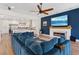 Open living room with a modern fireplace, recessed lights, a custom blue accent wall, and modern kitchen view at 7289 Sea Anchor Ct, Las Vegas, NV 89131