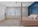 Main bedroom with a four poster bed, shuttered windows, and a blue accent wall at 7289 Sea Anchor Ct, Las Vegas, NV 89131
