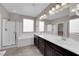 Bathroom with dual sinks, soaking tub, and separate glass shower at 7300 Lavender Rose Ave, Las Vegas, NV 89117