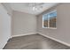 This bedroom features wood floors, a ceiling fan, and a large window at 7300 Lavender Rose Ave, Las Vegas, NV 89117