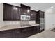 Granite countertops and stainless steel appliances complement dark wood cabinetry in this gourmet kitchen at 7300 Lavender Rose Ave, Las Vegas, NV 89117