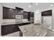 Well-equipped kitchen with granite countertops, stainless steel appliances, and dark wood cabinetry at 7300 Lavender Rose Ave, Las Vegas, NV 89117