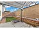 Landscaped backyard with shade structure, brick wall, and artificial turf at 779 Peregrine Falcon St, Henderson, NV 89015