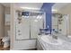 Bathroom with a shower over tub with glass doors, storage and a sink with a tiled countertop at 779 Peregrine Falcon St, Henderson, NV 89015