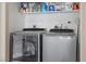 Well-equipped laundry room features modern Whirlpool washer and dryer, plus storage shelves at 779 Peregrine Falcon St, Henderson, NV 89015