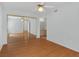 Bright bedroom featuring wood floors, ceiling fan, and mirrored closet doors at 7950 W Flamingo Rd # 1077, Las Vegas, NV 89147
