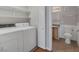 Bright laundry area features a washer, dryer, and open shelving for convenient storage solutions at 7950 W Flamingo Rd # 1077, Las Vegas, NV 89147