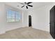 Bedroom featuring large window, neutral carpet, and a black paneled door at 8043 Tank Loop St, Las Vegas, NV 89166