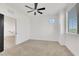 Bright bedroom featuring neutral carpet, round accent window, and a ceiling fan at 8043 Tank Loop St, Las Vegas, NV 89166