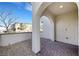 Covered front porch with beautiful brick floor, offering a shaded entryway into the home at 8043 Tank Loop St, Las Vegas, NV 89166