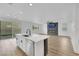 Bright, open concept living room featuring a sleek fireplace and modern kitchen with island at 8043 Tank Loop St, Las Vegas, NV 89166