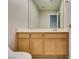 A neutral bathroom with a light wood vanity, a large mirror and tiled floors at 8105 Tropic Isle Cir, Las Vegas, NV 89128