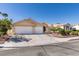 Street view of a beautiful stucco home with two-car garage, terra cotta roof and desert landscaping at 8105 Tropic Isle Cir, Las Vegas, NV 89128