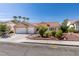 Inviting single-story home with a two-car garage, lovely landscaping, and a classic terra cotta roof at 8105 Tropic Isle Cir, Las Vegas, NV 89128