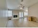 Spacious living room with fireplace, ceiling fan, wood floors, and view to the backyard at 8105 Tropic Isle Cir, Las Vegas, NV 89128