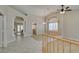 Open concept living area with high ceilings, tiled floors, and light wood railings to additional rooms at 8105 Tropic Isle Cir, Las Vegas, NV 89128