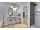 Modern bathroom featuring double sinks, vanity with framed mirrors, walk-in shower, and a walk-in closet at 8108 Artistic Heights Ct, Las Vegas, NV 89143