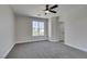 Bright bedroom with ceiling fan, neutral walls, plush carpet, and a window view of the outdoors at 8108 Artistic Heights Ct, Las Vegas, NV 89143
