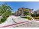 Exterior view of two-story house with a wide driveway, well-manicured lawn, and mature trees at 8108 Artistic Heights Ct, Las Vegas, NV 89143