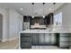 Modern kitchen features dark cabinetry, stainless steel appliances, and a large island with white countertops at 8108 Artistic Heights Ct, Las Vegas, NV 89143