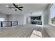 Bright living area with wood-look floors leading to a modern kitchen and staircase at 8108 Artistic Heights Ct, Las Vegas, NV 89143