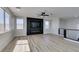 Bright living room featuring wood-look floors, a ceiling fan, and a modern fireplace at 8108 Artistic Heights Ct, Las Vegas, NV 89143