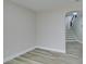 Open living area with light wood-look floors and a glimpse of the staircase through an archway at 8108 Artistic Heights Ct, Las Vegas, NV 89143