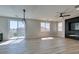 Bright living room with wood-look floors, modern lighting, fireplace, and large windows at 8108 Artistic Heights Ct, Las Vegas, NV 89143