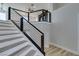 Modern staircase featuring sleek metal railings and light wood-look treads ascending to the second level at 8108 Artistic Heights Ct, Las Vegas, NV 89143