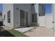 Outdoor patio with sliding glass door, rocks, artificial turf, and white privacy fence at 8218 Golden Flowers St, Las Vegas, NV 89139