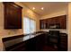 Well-lit kitchen with dark wood cabinets, black appliances, and ample counter space at 8218 Golden Flowers St, Las Vegas, NV 89139