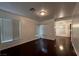 Open living room with dark wood floors, lots of natural light from large windows, and recessed lighting at 8218 Golden Flowers St, Las Vegas, NV 89139