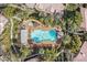 Aerial view of a sparkling community pool with seating areas surrounded by lush landscaping and palm trees at 8737 Red Brook Dr # 201, Las Vegas, NV 89128
