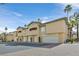 Exterior of townhomes featuring attached garages, neutral color palette, and well-kept landscaping at 8737 Red Brook Dr # 201, Las Vegas, NV 89128