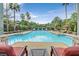 Community pool with lounge chairs surrounded by palm trees and well-manicured landscaping at 8737 Red Brook Dr # 201, Las Vegas, NV 89128