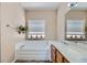 Bright bathroom boasts a soaking tub, double sinks, and a large mirror with decorative plants at 8934 Libertyvale Dr, Las Vegas, NV 89123
