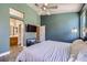 This bedroom has a tv, ceiling fan, blue accent wall, and ensuite bathroom with wood vanity at 8934 Libertyvale Dr, Las Vegas, NV 89123