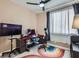 Functional bedroom with a desk, TV, and a window to provide plenty of space and natural light at 8934 Libertyvale Dr, Las Vegas, NV 89123