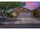 Charming single-story home featuring a two-car garage, desert landscaping, and a welcoming facade at dusk at 8934 Libertyvale Dr, Las Vegas, NV 89123