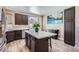 Modern kitchen features an island with a white countertop, dark cabinets, stainless appliances, and wood-style flooring at 8934 Libertyvale Dr, Las Vegas, NV 89123