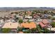 Panoramic aerial view of a residential area, highlighting community layout with pools, green spaces, and tiled roofs, offering charm at 905 White Thunder St, Henderson, NV 89002