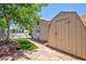 A serene backyard featuring a patio, manicured lawn, stone path, and a storage shed offering outdoor living and functionality at 905 White Thunder St, Henderson, NV 89002