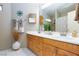 Bright bathroom featuring double sinks, white countertops and tiled floors, plus wood cabinetry at 905 White Thunder St, Henderson, NV 89002