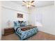 Comfortable bedroom with a bed with blue floral accents, side tables and lamps at 905 White Thunder St, Henderson, NV 89002
